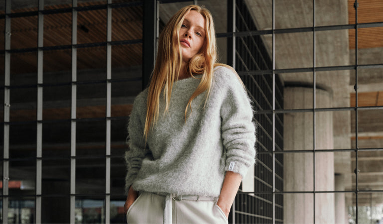 Entdecken Sie den zeitlosen weichen Strickpullover in Hellgrau-Melange für Damen.