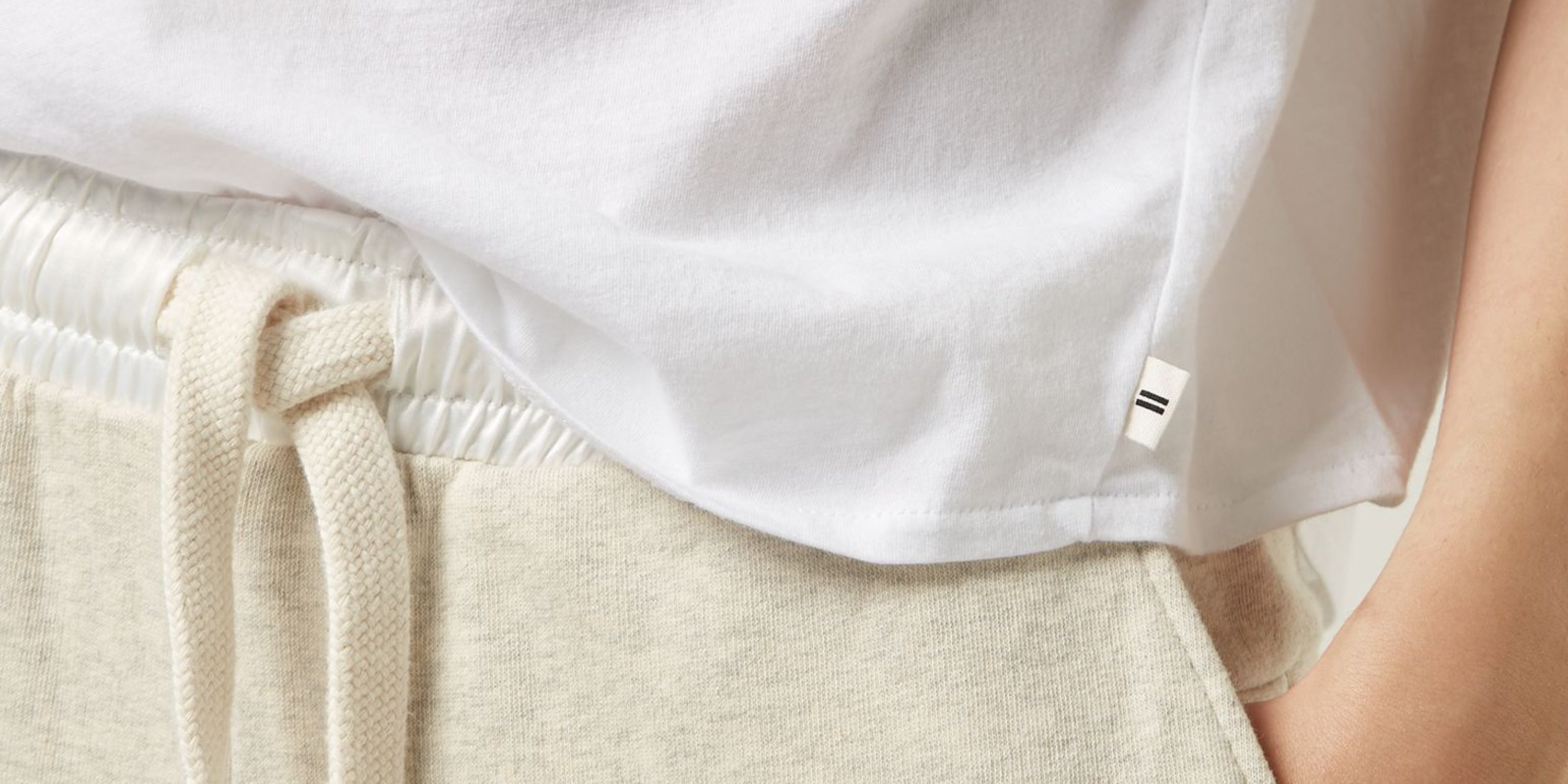 Care - Close-up of person wearing a white t-shirt and soft white melee joggers.